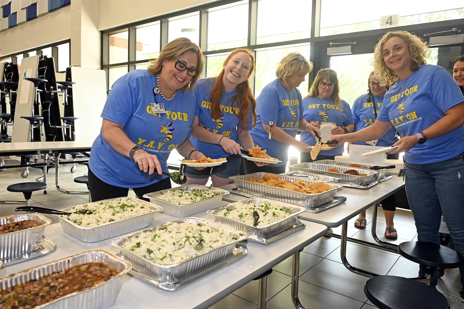 Yeager Elementary School staff serve themselves from a catered lunch provided to them from Cabo Bob’s Burritos.